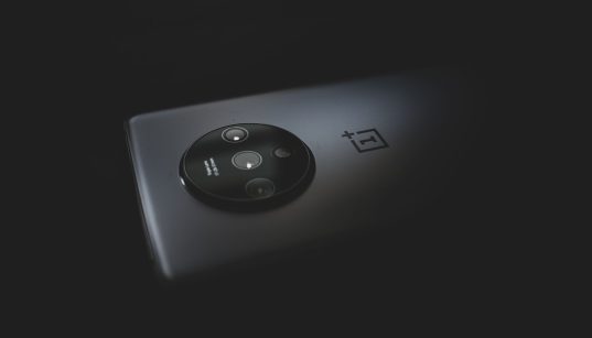 Close-up do módulo de câmera de um smartphone moderno sobre fundo escuro.