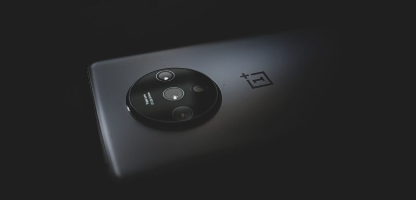 Close-up do módulo de câmera de um smartphone moderno sobre fundo escuro.