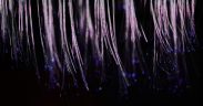 Fibras ópticas azuis luminosas formando feixes abstratos sobre fundo escuro.