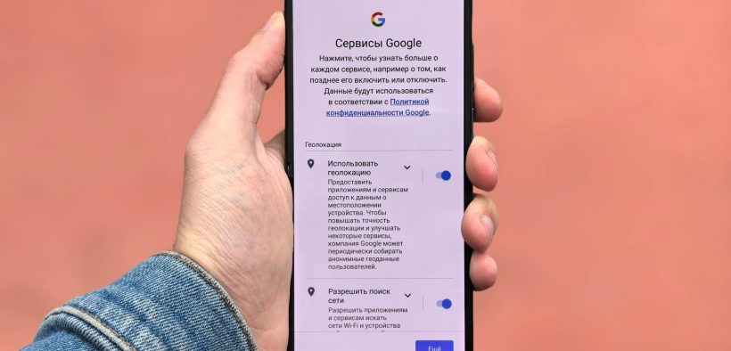 Pessoa segura um smartphone que exibe a tela de configurações do Google.