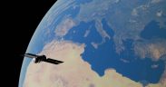 Ilustração digital de um satélite orbitando a Terra sobre a região do Mediterrâneo.