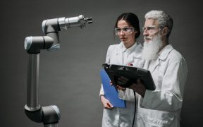 Pesquisadores examinam um braço robótico em um laboratório de tecnologia.