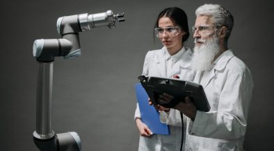 Pesquisadores examinam um braço robótico em um laboratório de tecnologia.