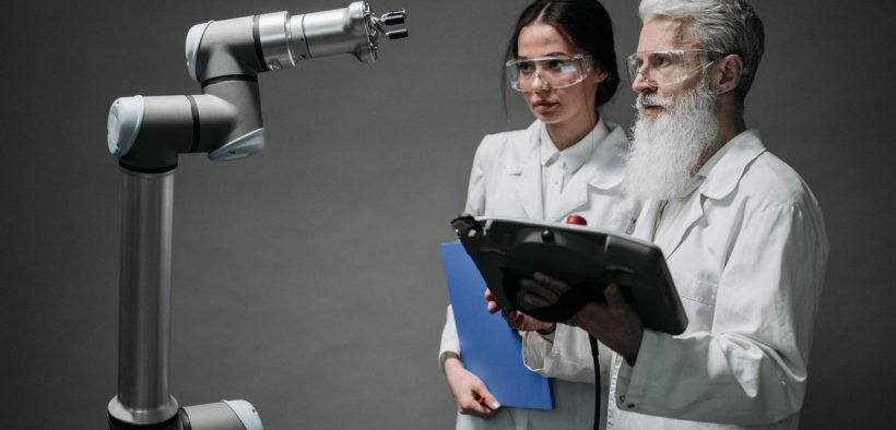Pesquisadores examinam um braço robótico em um laboratório de tecnologia.