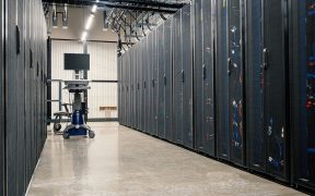 Armários metálicos com servidores, equipamentos de rede e cabos em um data center moderno