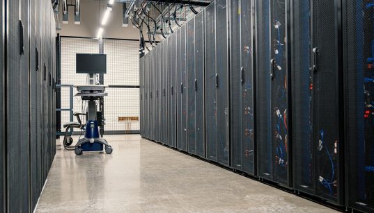 Armários metálicos com servidores, equipamentos de rede e cabos em um data center moderno