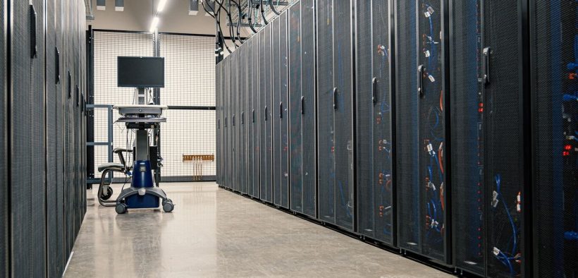 Armários metálicos com servidores, equipamentos de rede e cabos em um data center moderno