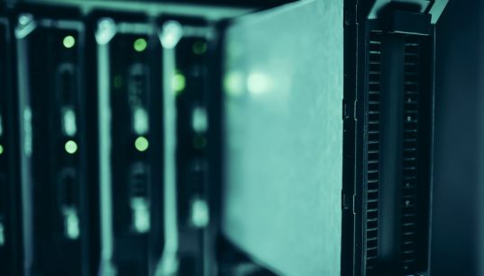 Racks de servidores em um data center moderno, representando a infraestrutura usada para executar modelos de inteligência artificial.