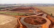 Vista aérea de uma área em desenvolvimento com obras e movimentação de terra.