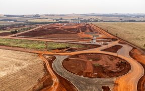 Vista aérea de uma área em desenvolvimento com obras e movimentação de terra.