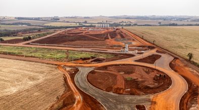 Vista aérea de uma área em desenvolvimento com obras e movimentação de terra.