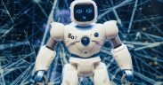 Robô humanoide com detalhes luminosos diante de um fundo de rede digital futurista.