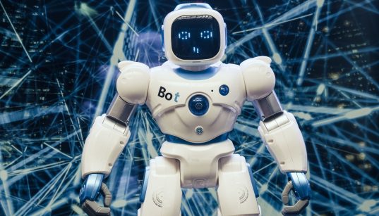 Robô humanoide com detalhes luminosos diante de um fundo de rede digital futurista.