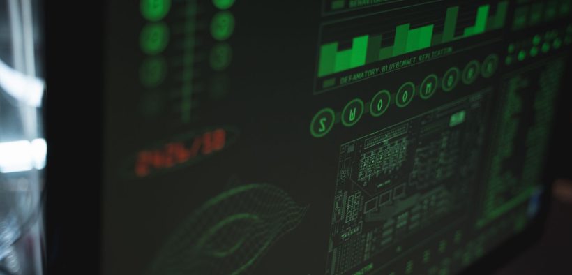 Tela de computador exibindo interfaces digitais de cibersegurança e proteção de dados em tons verdes.