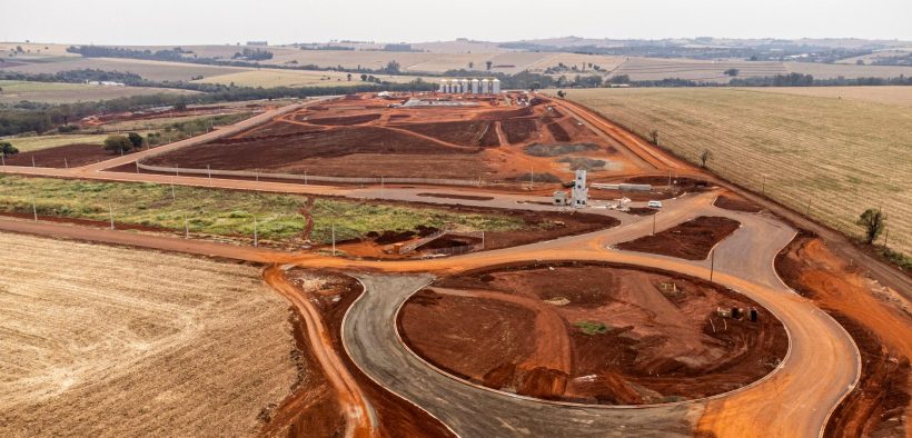 Vista aérea de uma área em desenvolvimento com obras e movimentação de terra.